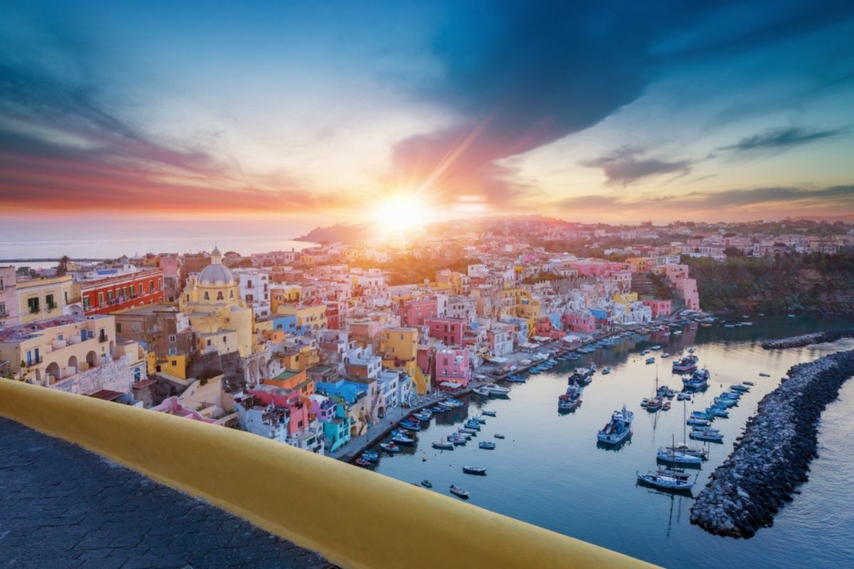 Immagine di Procida al tramonto con le casette illuminate