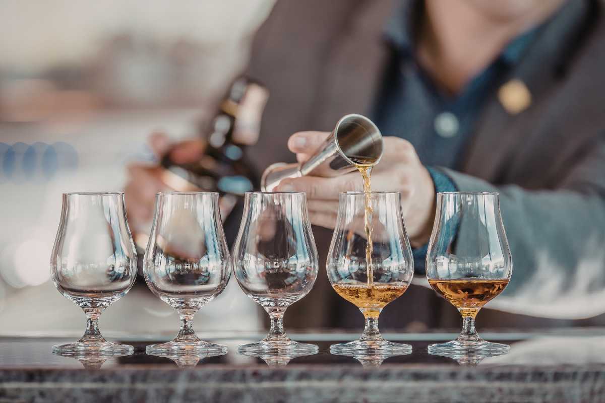 Visita al Museo del Liquore Strega, con persone che degustano e esplorano la storia della produzione del liquore.