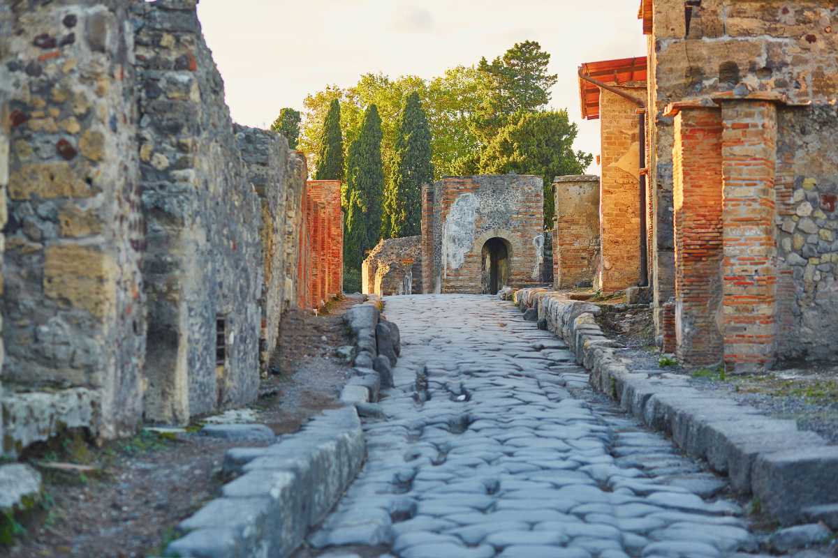 Vista serale delle rovine di Pompei illuminate, con il Vesuvio sullo sfondo